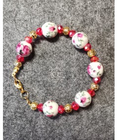 Pulsera dorada de cerámica y cristal rojo