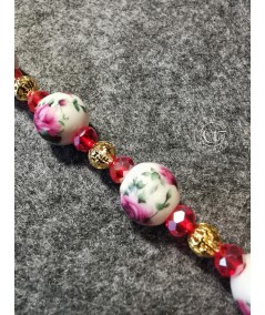 Pulsera dorada de cerámica y cristal rojo